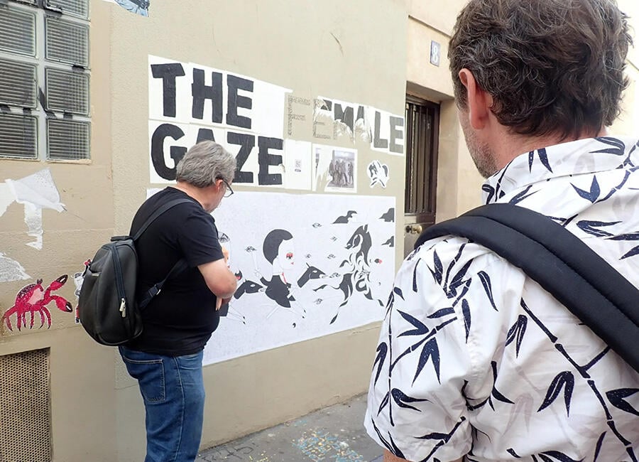 A guide pointing out street art in Paris