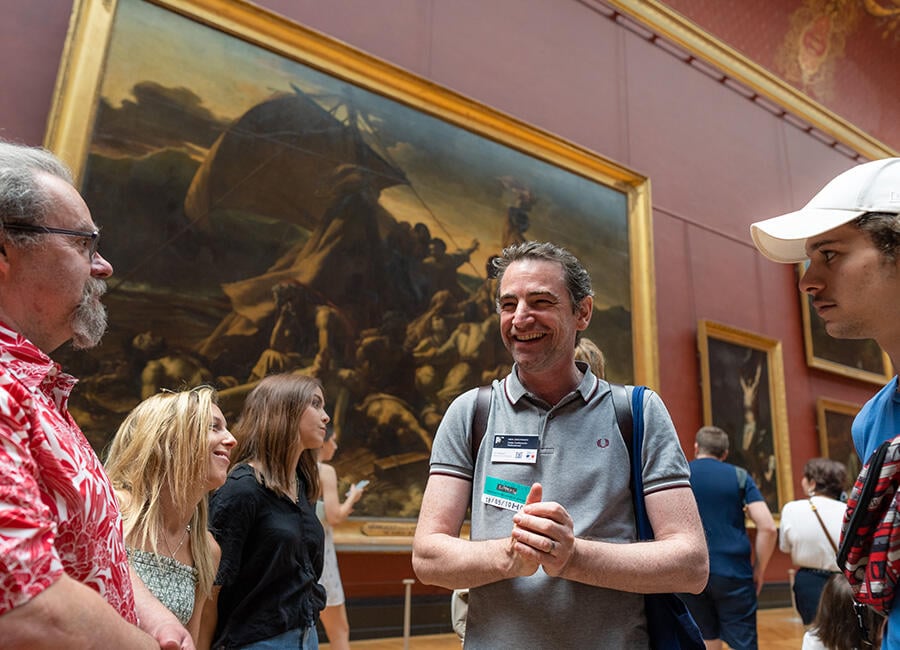 A guide laughing while in the Louvre