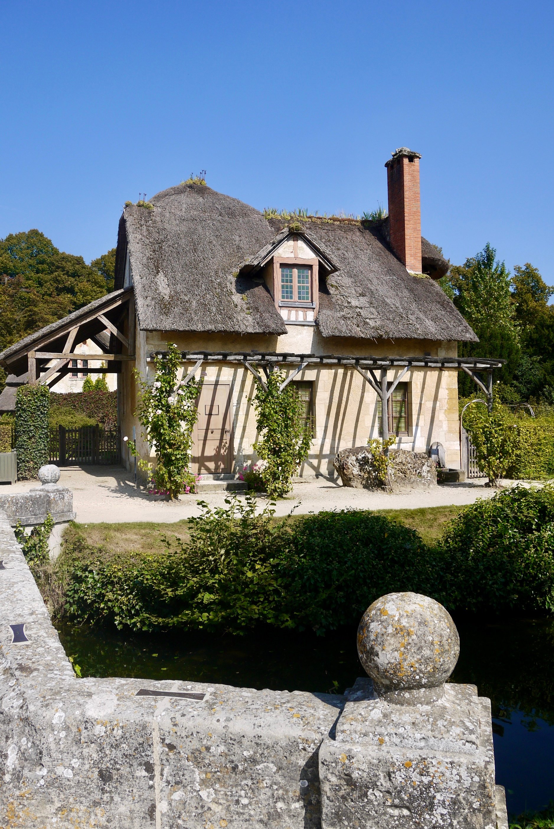 Two rustic Npormandy style houses in the Queen's Hamlet in Versailles on a sunny day.